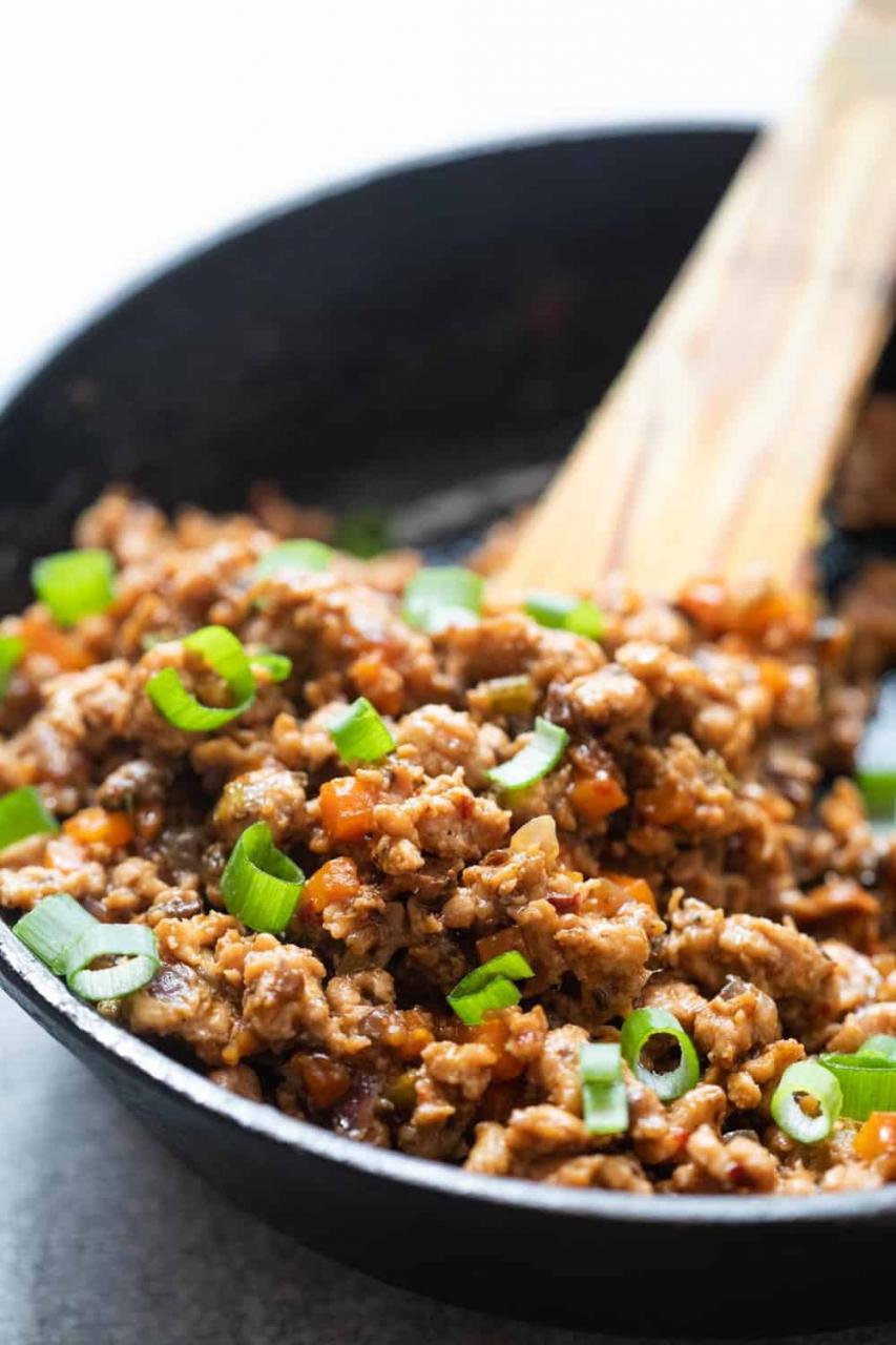 Filling for chicken lettuce wraps in a cast iron pan with a spatula