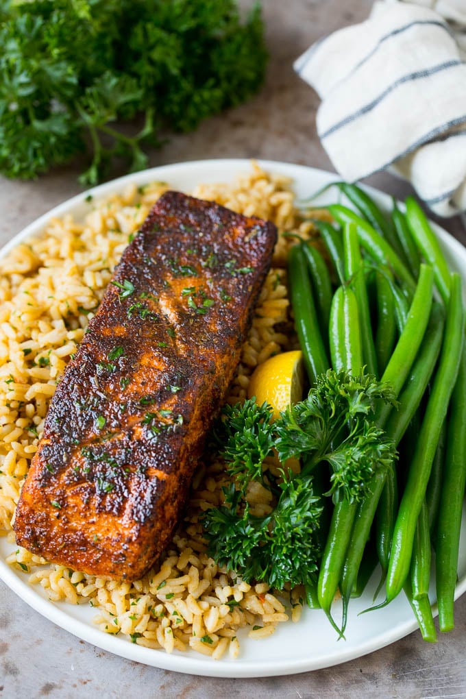 Blackened salmon served with rice and green beans.