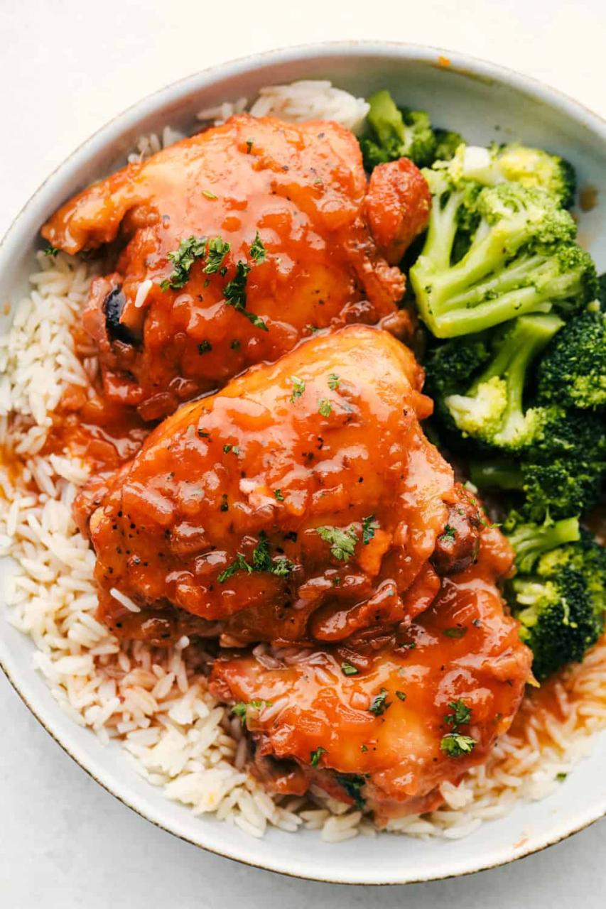 Apricot Chicken on top of rice with a side of broccoli on a plate. 