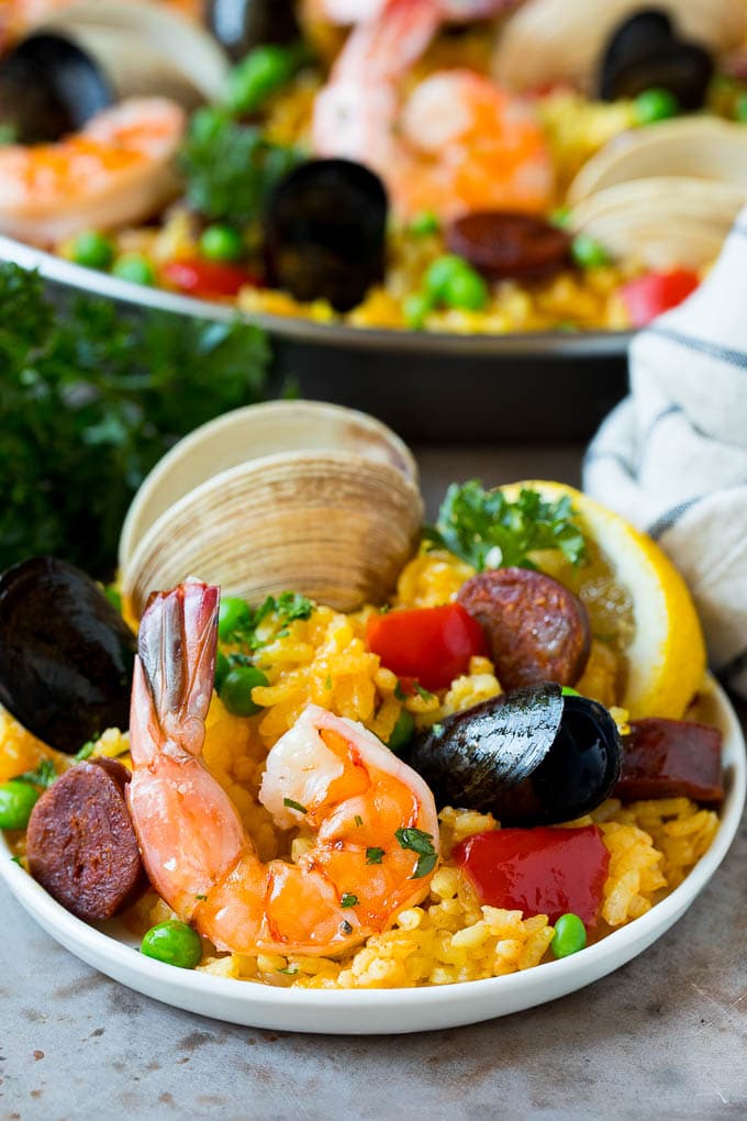 A plate of seafood paella garnished with parsley.